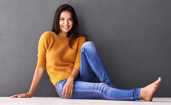 Woman lounging around in jeans and sweater