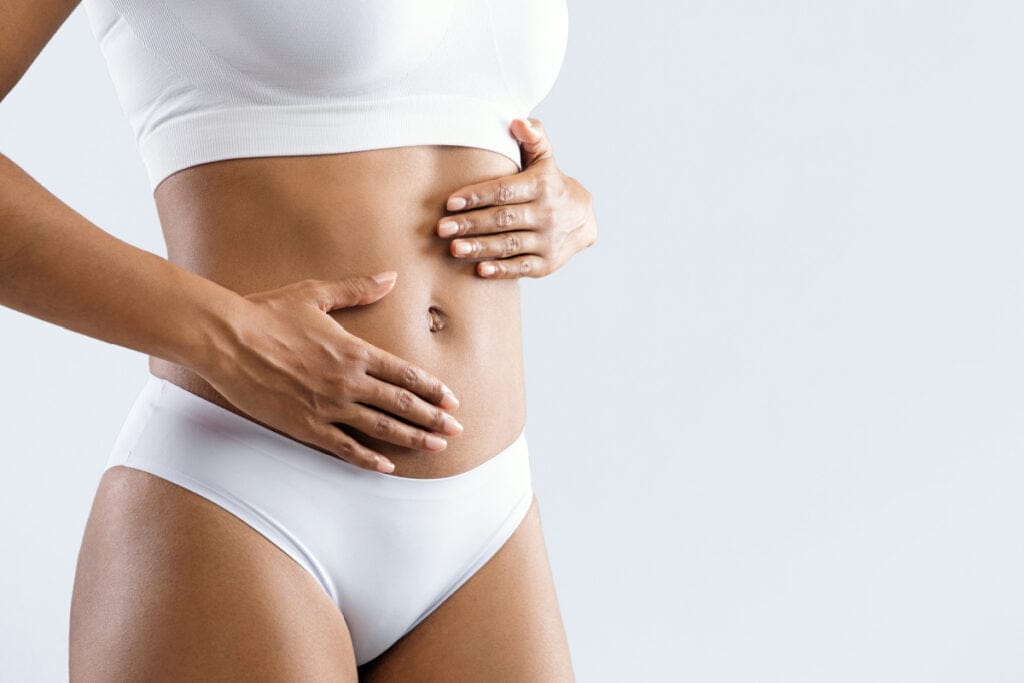 Woman in white underwear with hands over stomach